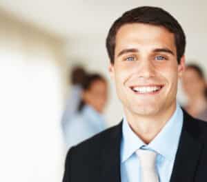 dark haired, light eyed male in tie smiling with a fresh face