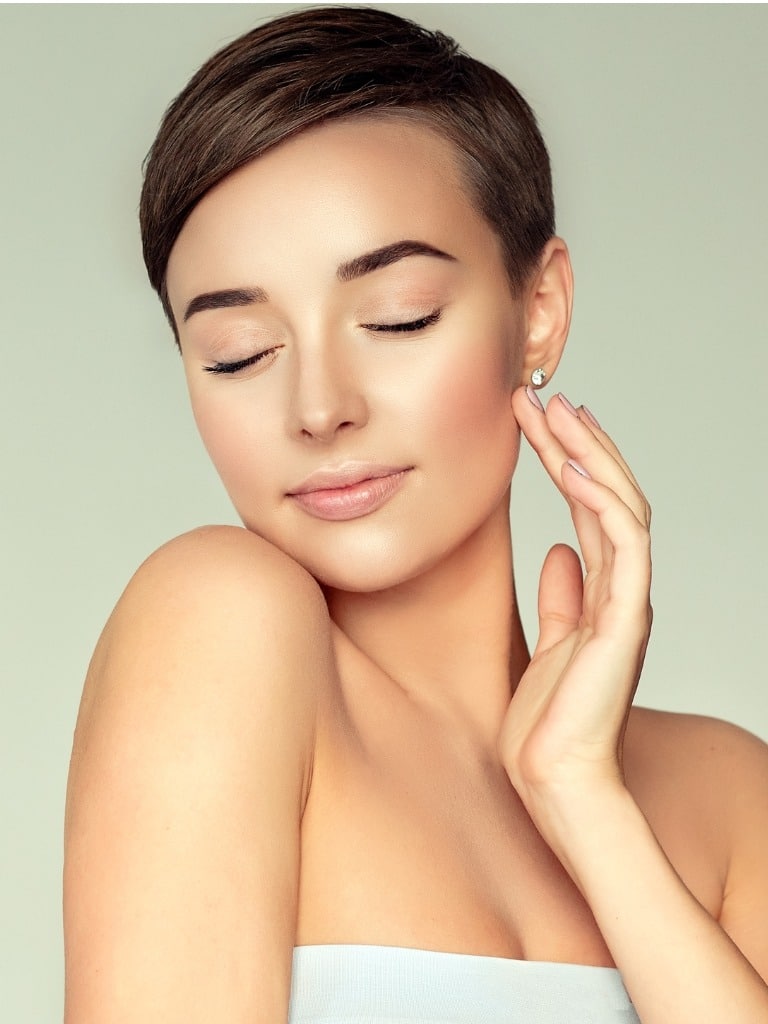 Young brown haired woman practicing skin care