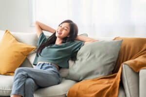 Relaxed,Young,Asian,Woman,Enjoying,Rest,On,Comfortable,Sofa,At